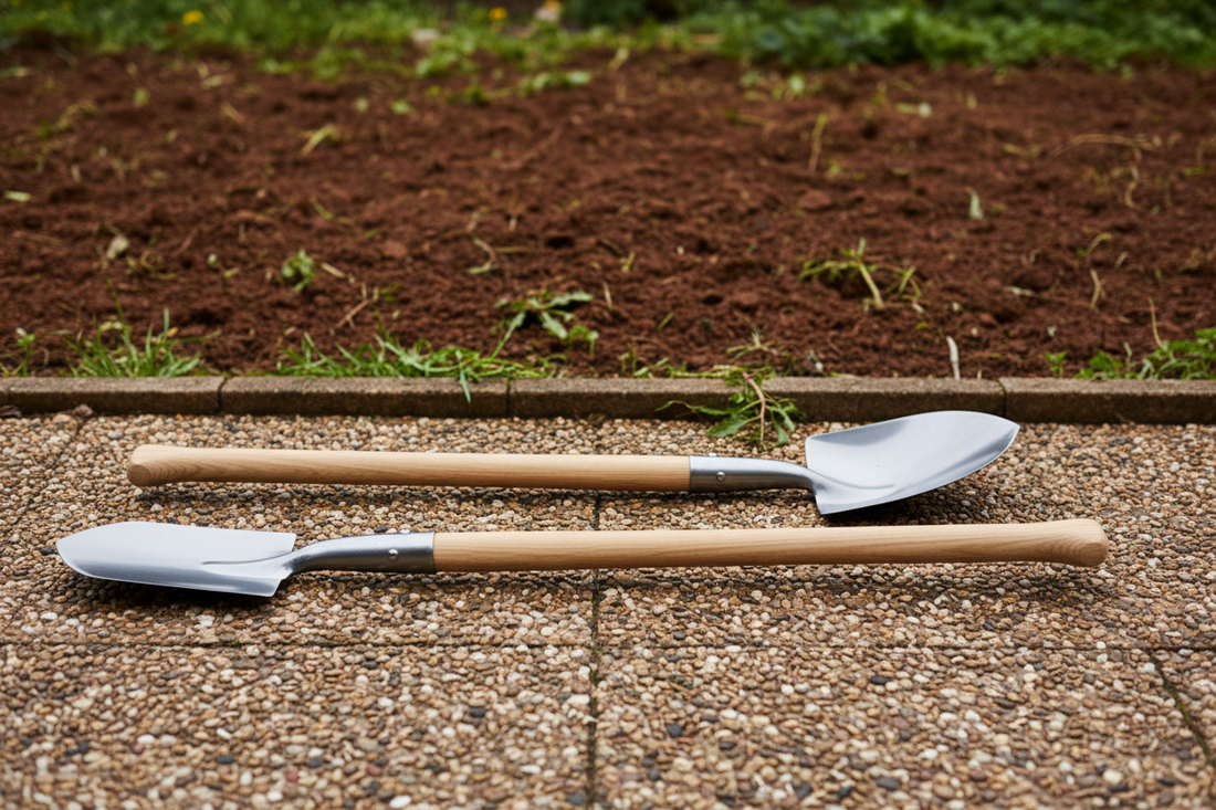 Flat-bladed digging spade and curved shovel laid side by side on a UK garden path with clay soil in the background