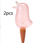 Pink bird-shaped glass plant watering globe with terracotta spike, set of 2