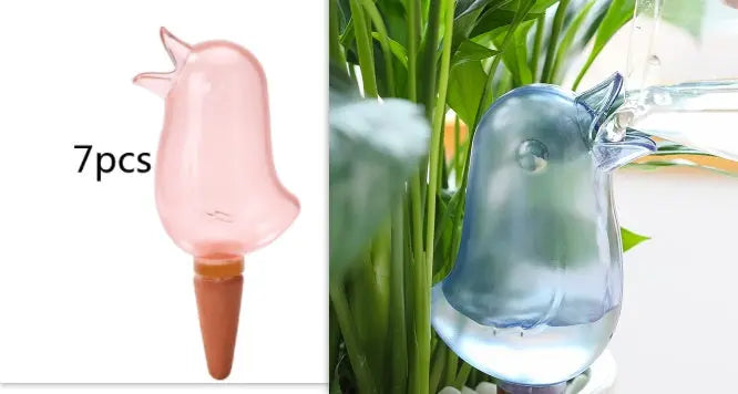 Bird-shaped plant watering globes in use for indoor garden self-watering