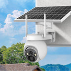Solar-powered security camera on a wall with a blue sky and trees in the background