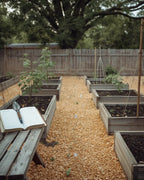 A planned USA vegetable garden in full season with the printable garden planner open on the bench